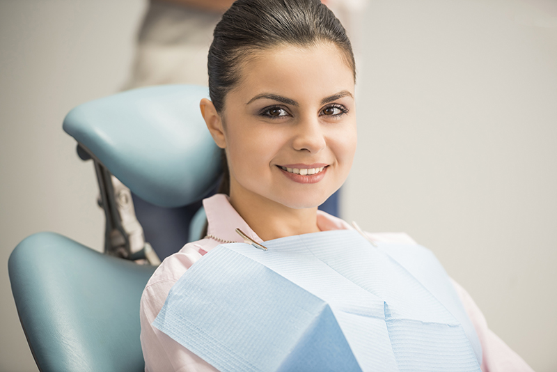 brunette woman with pulled back ponytail at the dentist in operatory chair